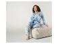Une femme porte un pyjama bleu tie-dye avec un pantalon et un haut assorti.