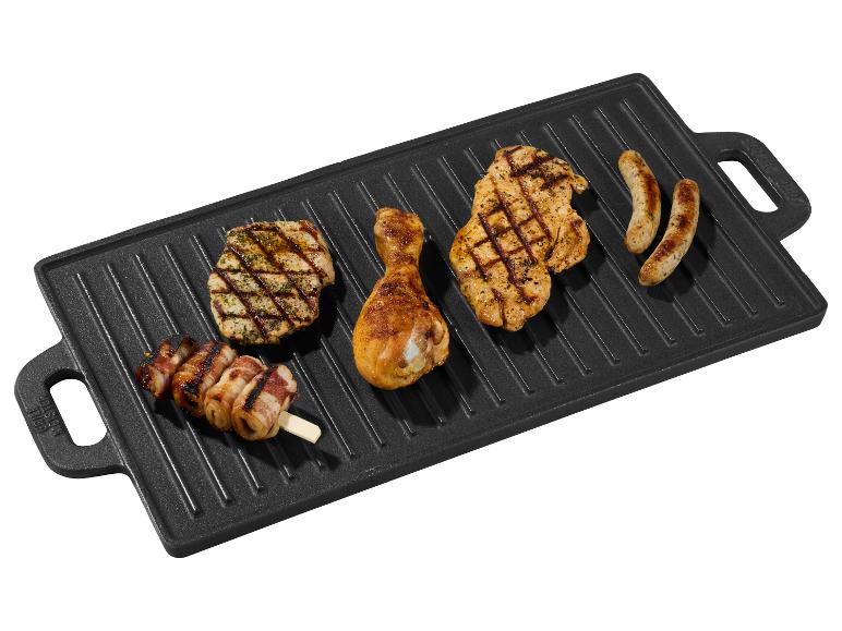 Poulet grillé, saucisses et brochettes de bacon sur une plaque de gril en fonte.