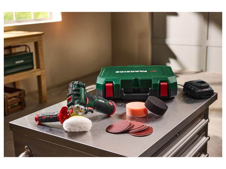 Polisseuse sans fil avec batterie, chargeur, mallette et accessoires sur une table métallique.