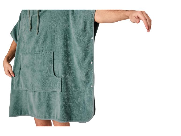 Poncho de bain vert avec capuche et poche, un bras tendu