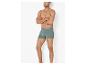 Caleçon boxer vert pour homme, porté par un homme aux bras croisés.