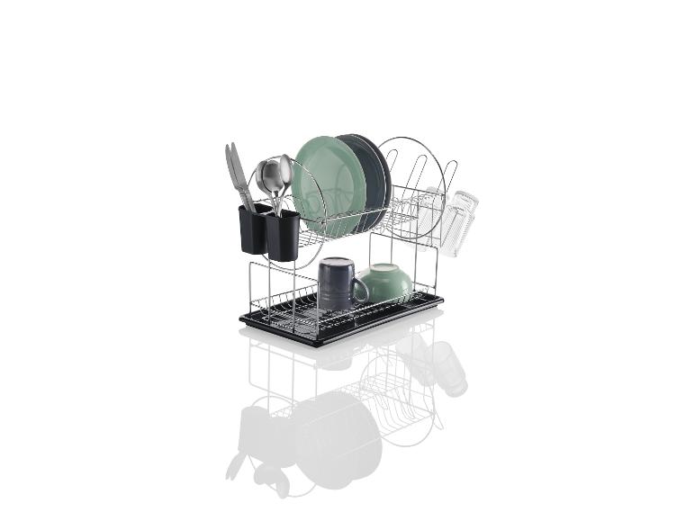 Un égouttoir à vaisselle en argent avec des assiettes, des tasses et des couverts.