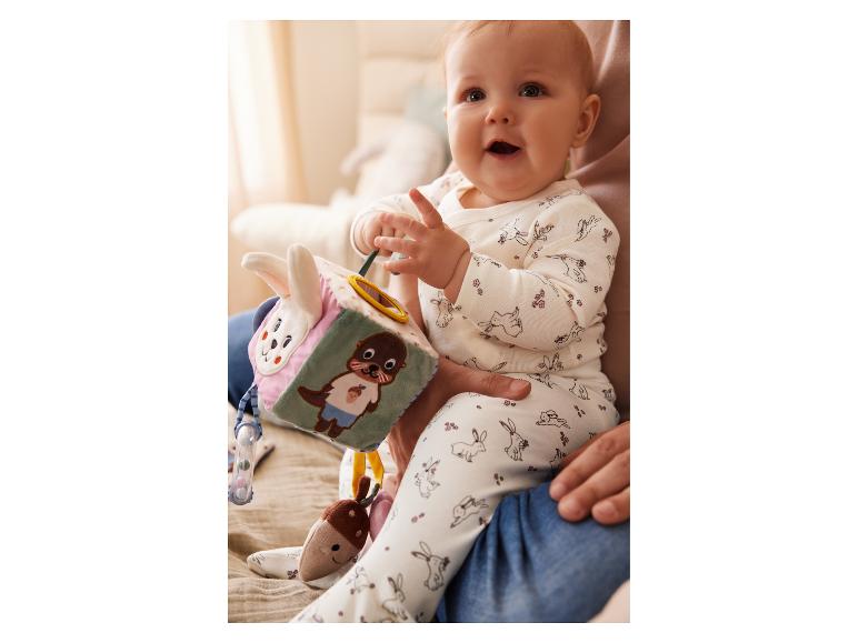 Un bébé joue avec un cube d'activités Little Dutch.