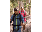 Deux randonneurs avec des sacs à dos et des bâtons de trekking sur un sentier forestier.