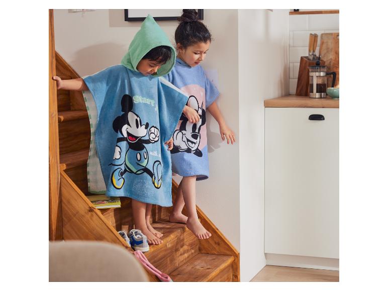 Enfants portant des ponchos de bain Mickey Mouse.