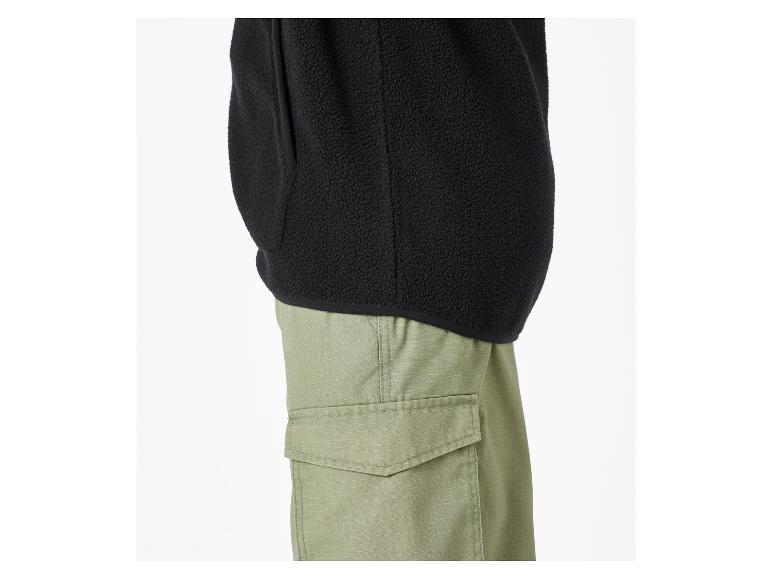 Veste polaire noire avec pantalon cargo vert.