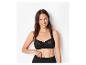 Femme souriante en soutien-gorge en dentelle noire et culotte noire.