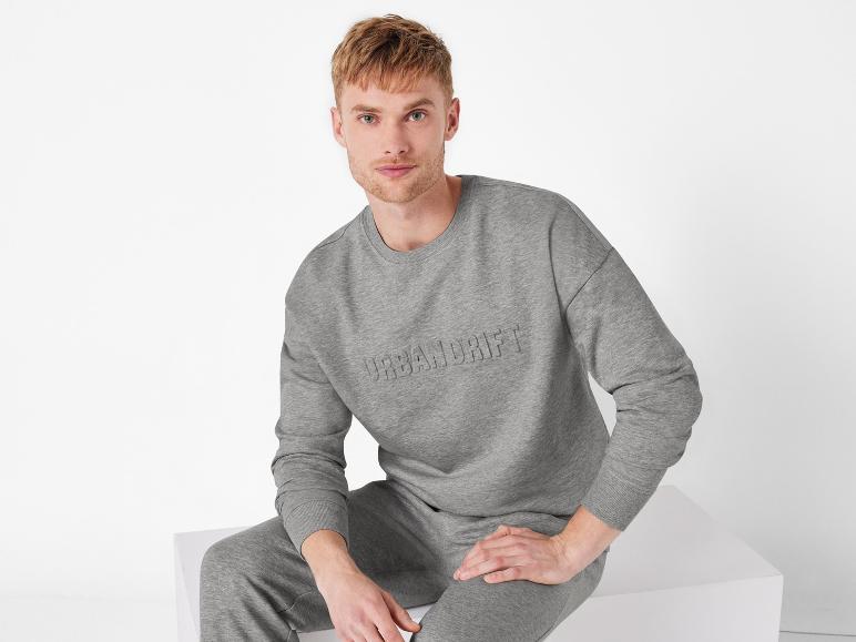 Un homme portant un sweat-shirt gris Urban Drift et un pantalon de jogging.
