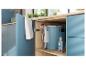 Armoire ouverte avec un nettoyeur de tapis bleu, une solution détachante et une serviette blanche.