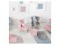 Chaises et poufs pour enfants aux couleurs pastel, avec des cadres au mur.