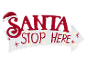 Panneau blanc en forme de flèche avec texte rouge 'SANTA STOP HERE' et bonnet de Père Noël, illuminé.