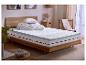 Chambre avec lit, matelas, surmatelas, oreillers, couettes et table de chevet.