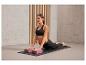 Une femme faisant du yoga sur un tapis avec deux blocs roses.