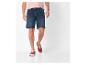 Modèle portant un short en jean et des baskets rouges.