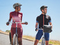 Deux personnes en tenue de vélo avec des casques sur des vélos.