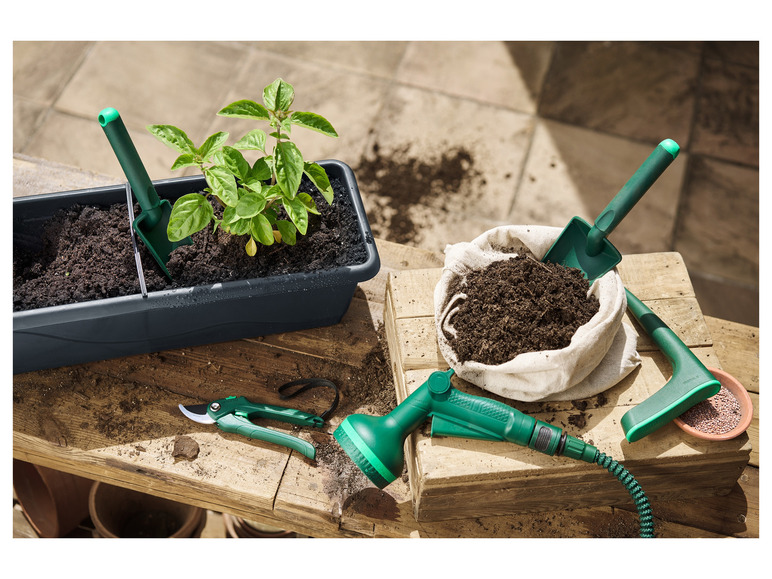 Outils de jardinage, y compris un arrosoir, des ciseaux d'élagage et une binette.