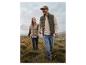 Homme et femme dans la nature, portant des gilets matelassés et des jeans.