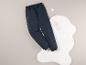 Un pantalon de survêtement noir sur un tapis blanc en fourrure.