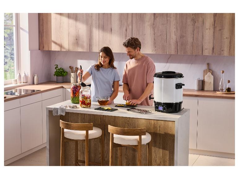 Stérilisateur électrique SILVERCREST® SEAD 1800 B2 sur un îlot de cuisine avec un couple cuisinant