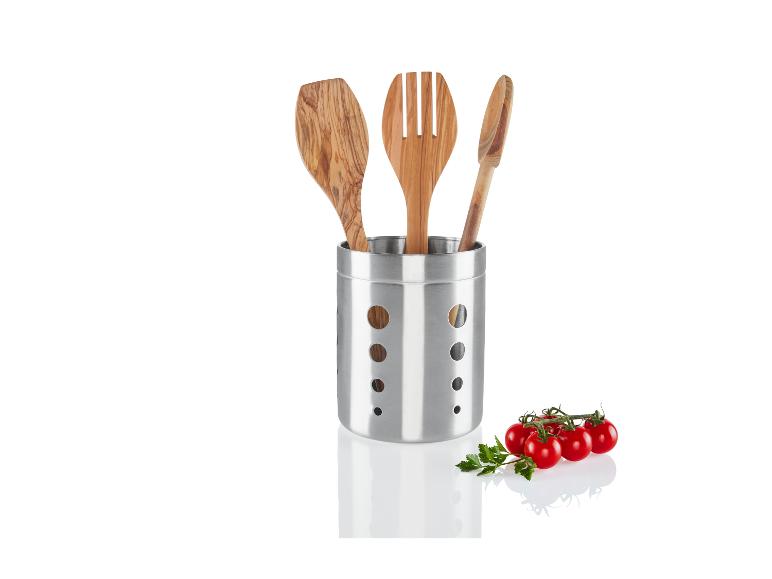 Ustensiles de cuisine en bois dans un support en acier avec des tomates.