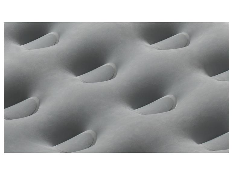 Matelas gonflable gris avec un motif ondulé.