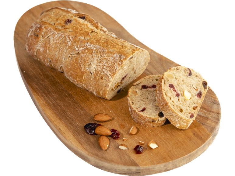 Pain aux fruits secs et noix sur une planche à découper en bois.