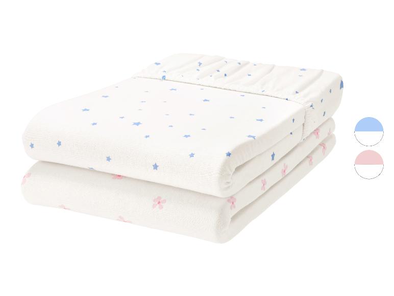 Lot de 2 draps-housses pour bébé, un blanc à étoiles bleues et un blanc à fleurs roses.