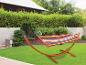 Hamac multicolore sur un support en bois dans un jardin.