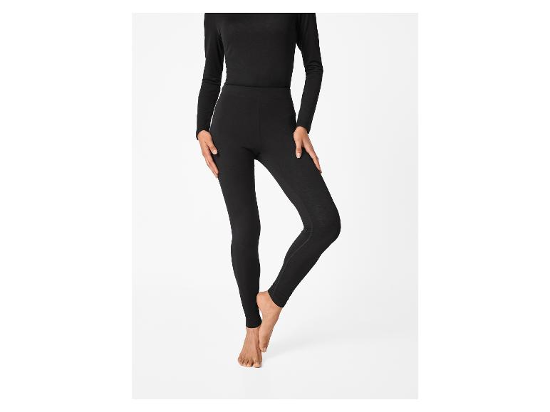 Une personne portant un haut noir à manches longues et des leggings noirs.