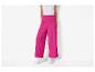 Pantalon large rose vif et baskets blanches.