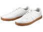 Baskets blanches en cuir avec semelles en caoutchouc brun.