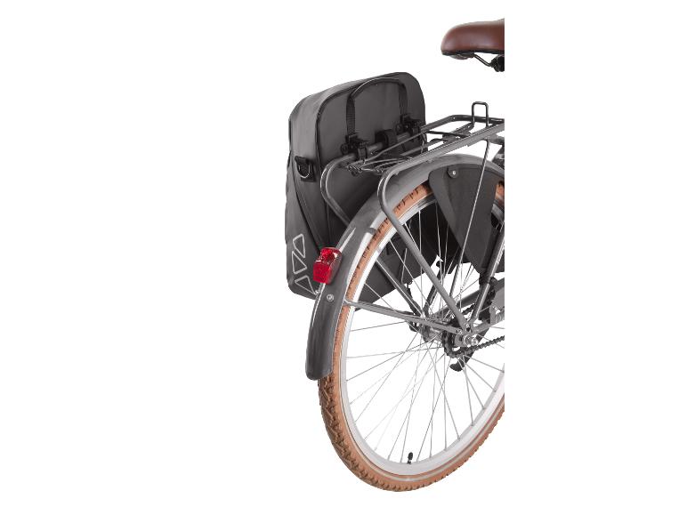Sacoches de vélo arrière noires sur un porte-bagages de vélo avec un pneu marron.