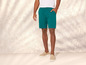 Un homme portant un pantalon vert et des baskets beiges.