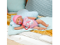 Poupée bébé endormie avec bonnet rose et barboteuse à motif licorne, avec sucette.