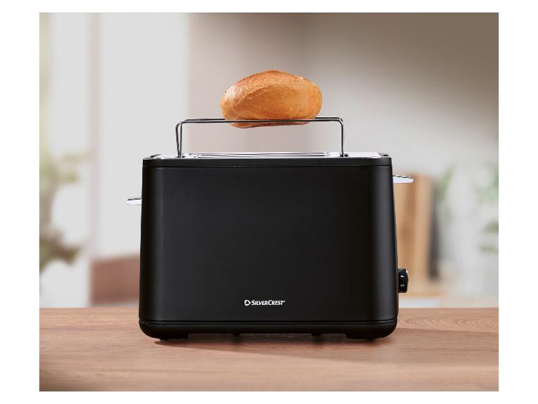 Grille-pain SilverCrest avec un petit pain sur le dessus, sur une surface en bois.