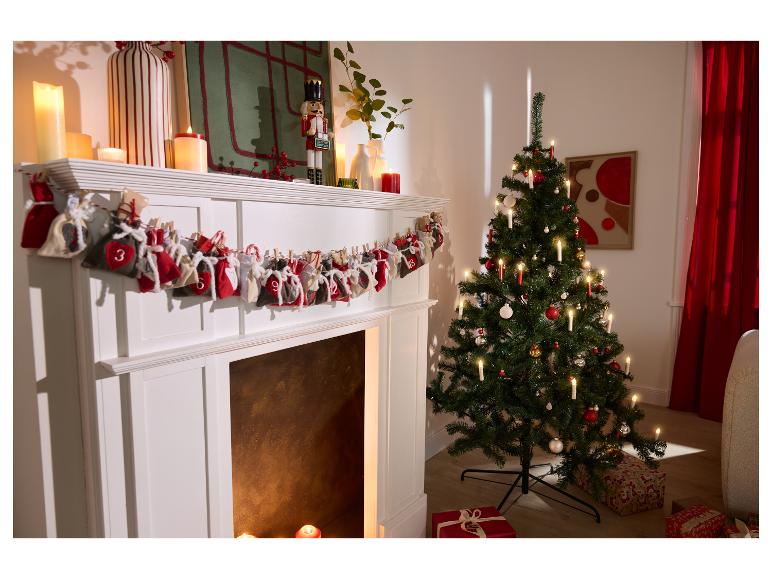 Cheminée blanche décorée d'un calendrier de l'avent et d'un sapin de Noël illuminé.