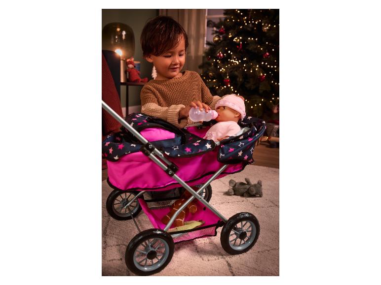 Un enfant joue avec une poussette et une poupée.