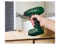 Une perceuse-visseuse sans fil Parkside verte est utilisée pour assembler une armoire.