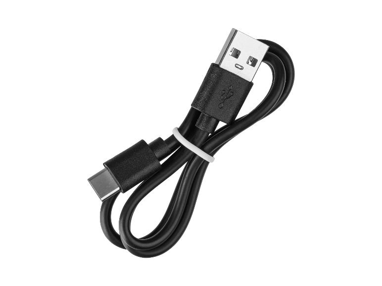 Câble de charge noir USB-C vers USB-A, enroulé et attaché avec une bande blanche.