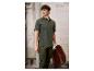 Homme en polo vert et pantalon cargo, tenant une chaise pliante.