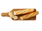 Deux baguettes et des tranches coupées sur une planche à découper en bois.