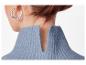 Femme avec des boucles d'oreilles argentées et un pull bleu à col en V