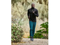 Homme en sweat-shirt noir et pantalon bleu, courant dans les bois.