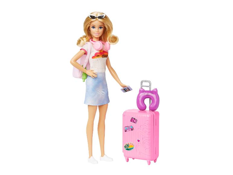Poupée aux cheveux blonds, lunettes de soleil, casque rose, t-shirt blanc, jupe bleue et valise rose.