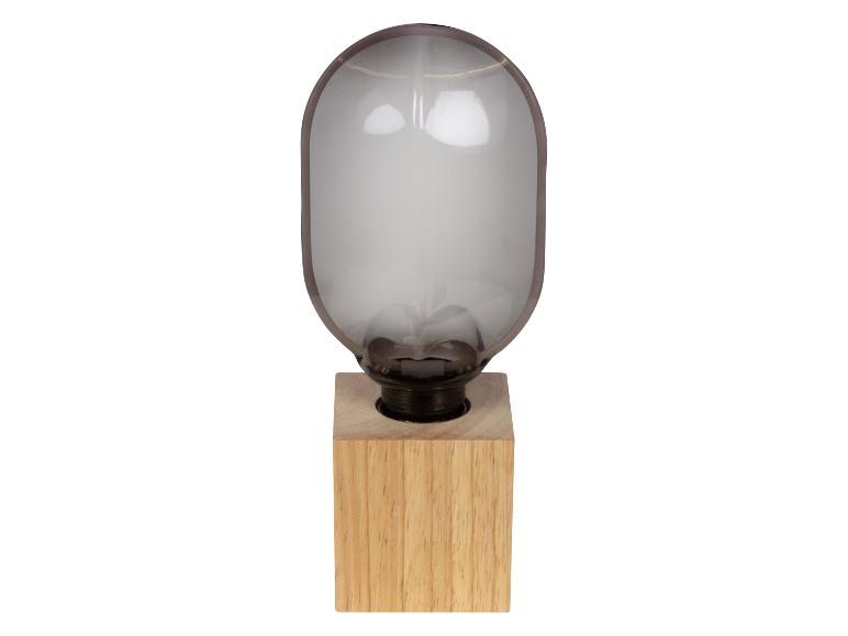 Lampe de table avec base en bois et abat-jour en verre en forme de capsule.