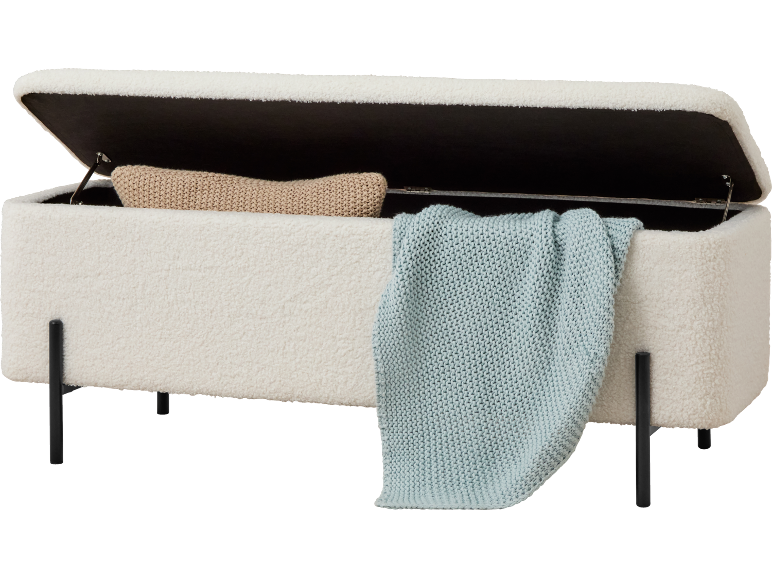 Banc de rangement blanc en tissu teddy avec un coussin beige et une couverture tricotée bleu clair.