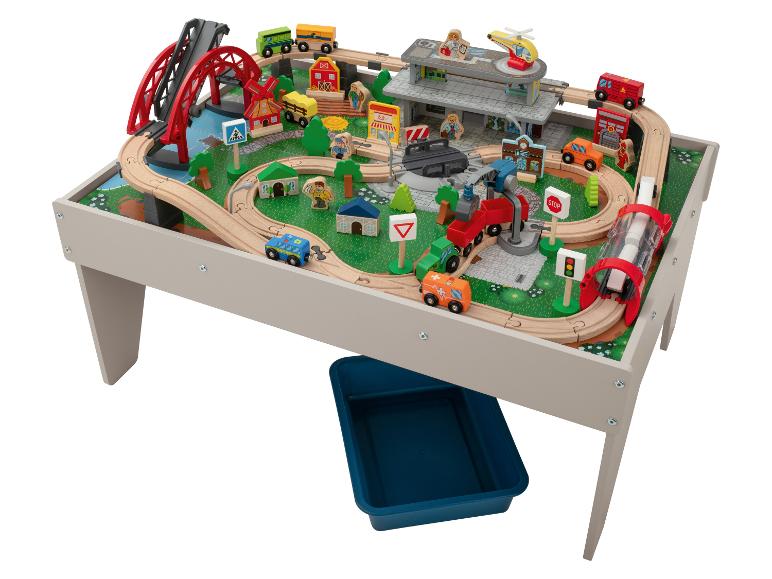 Table de jeu en bois avec trains, ponts, bâtiments et figurines.
