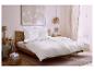 Chambre avec lit, literie blanche, tables de chevet et art mural aux tons neutres.