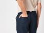 Pantalon foncé et t-shirt beige décontracté.