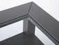 Détail d'une table basse gris foncé avec un plateau en verre.